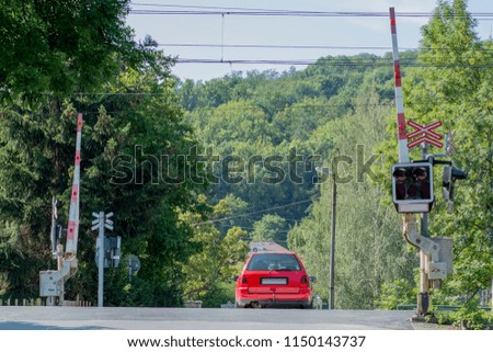 Railroad crossing with barrier and a car