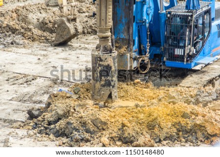 Hydraulic drilling machine is boring holes in the construction site for bored piles work. Bored piles are reinforced concrete elements cast into drilled holes, also known as replacement piles. Royalty-Free Stock Photo #1150148480