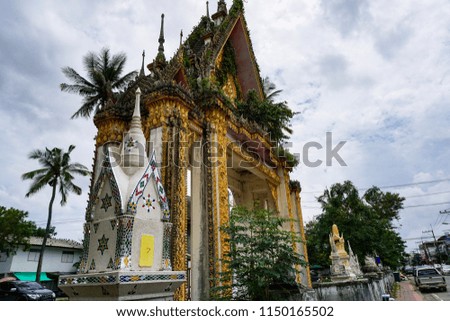 Ancient stucco on archway of buddhist temple with thai language name meaning to Brightness Temple