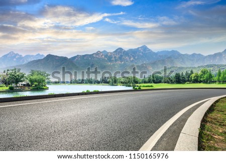 Empty asphalt highway and green mountain nature landscape at sunset Royalty-Free Stock Photo #1150165976