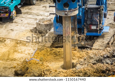 Hydraulic drilling machine is boring holes in the construction site for bored piles work. Bored piles are reinforced concrete elements cast into drilled holes, also known as replacement piles. Royalty-Free Stock Photo #1150167440