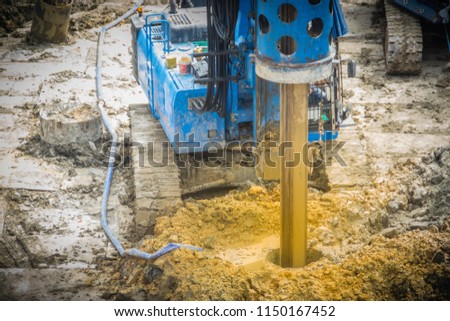 Hydraulic drilling machine is boring holes in the construction site for bored piles work. Bored piles are reinforced concrete elements cast into drilled holes, also known as replacement piles. Royalty-Free Stock Photo #1150167452