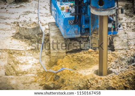 Hydraulic drilling machine is boring holes in the construction site for bored piles work. Bored piles are reinforced concrete elements cast into drilled holes, also known as replacement piles. Royalty-Free Stock Photo #1150167458