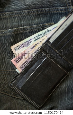 Indian currency notes in a personal wallet placed on a jeans.