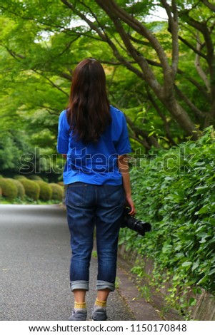 A woman taking a picture of trees
