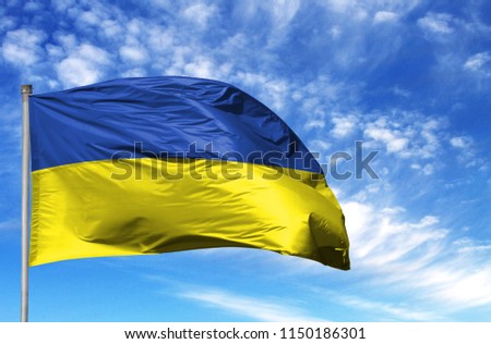 National flag of Ukraine on a flagpole in front of blue sky