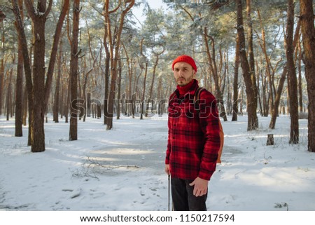 Enjoy moment. Tourist standing alone in orange cap and red plaid shirt, jacket. Travel lifestyle and emotions concept. Film effects colors. Wanderlust, hiking. Winter holiday. Christmas.