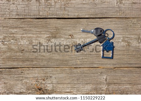 the keys to the house lie on a wooden background, the concept of buying a property