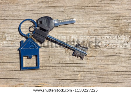 the keys to the house lie on a wooden background, the concept of buying a property