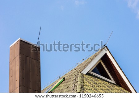 Close up of lightning protection rod wire system on private house roof and chimney.