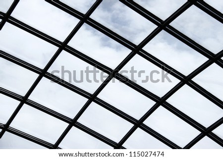 A blue cloudy sky through a plexiglass skylight roof.