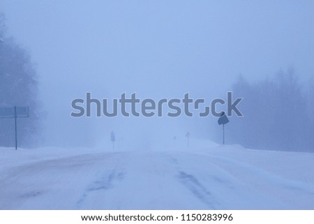 snow and fog on the winter road landscape / view of the seasonal weather a dangerous road, a winter lonely landscape