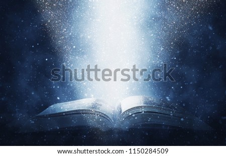 image of open antique book on wooden table with glitter background Royalty-Free Stock Photo #1150284509