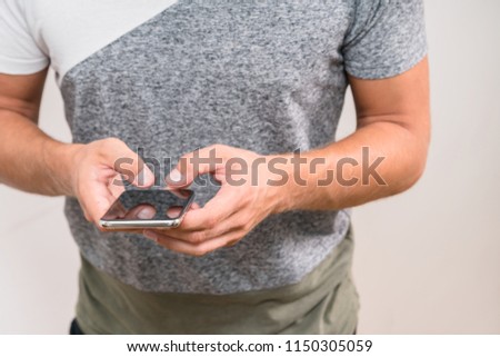 Close up shot of man's hands holding smart cell phone with blank copy space screen for your text. Student typing a message on mobile phone while sitting at the cafe after classes at university
