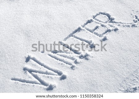 Winter. Hand drawn text on fresh snow in sunny day