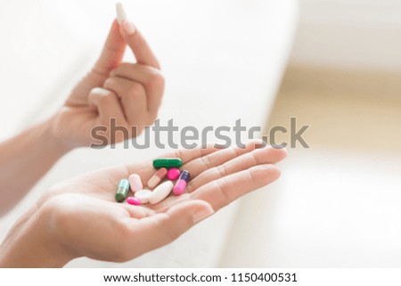 Woman hand with pills medicine tablets and capsule in her hands. Healthcare, medical supplements concept