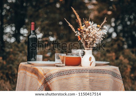 Bouquet and wine on the table, orange, vintage colored photo