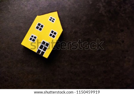 Yellow wooden house model isolated on table background. House concept and free copy space.