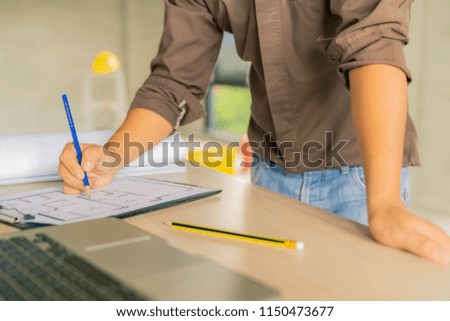 civil architect engineer choose color of building with laptop,engineering and architecture concept.Blue print is fake only for stock photo.