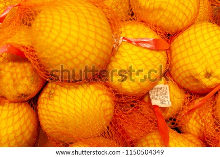 Fresh oranges packed in bright crane mesh