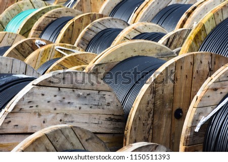 Wooden Coils Of Electric Cable Outdoor. High and low voltage cables in the storage. Royalty-Free Stock Photo #1150511393