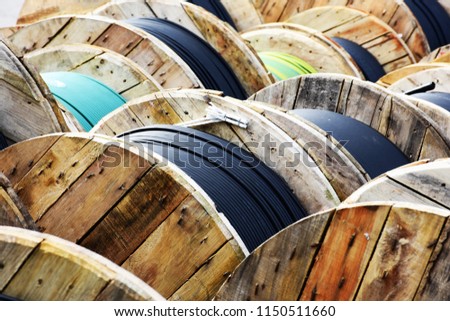Wooden Coils Of Electric Cable Outdoor. High and low voltage cables in the storage. Royalty-Free Stock Photo #1150511660