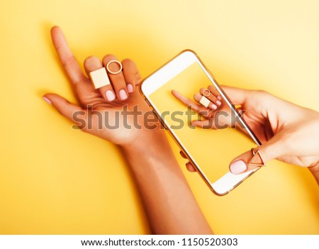 womans hand taking picture of her new manicure with fashion jewe