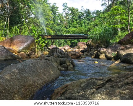 The wooden bridge over the beautiful stream in Thailand.