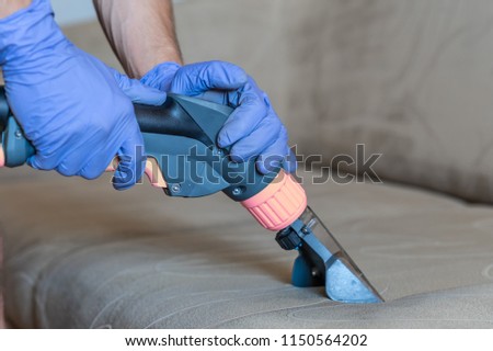 Closeup of upholstered Sofa chemical cleaning with professionally extraction method. Royalty-Free Stock Photo #1150564202