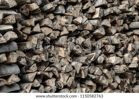 Natural wood background, logs of chopped firewood are stacked in a row