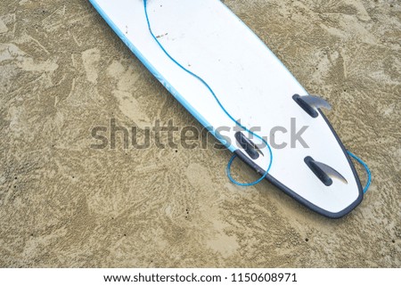 Surfboard on clear sand beach with copy space for content
