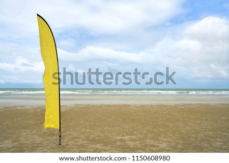 Yellow flag on sea beach in the beautiful sky day
