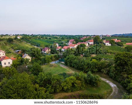 Town above the trees with dramatic sky with the green color.  