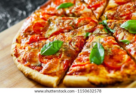 sliced Pizza with Mozzarella cheese, Tomatoes, pepper, Spices and Fresh Basil. Italian pizza. Pizza Margherita or Margarita