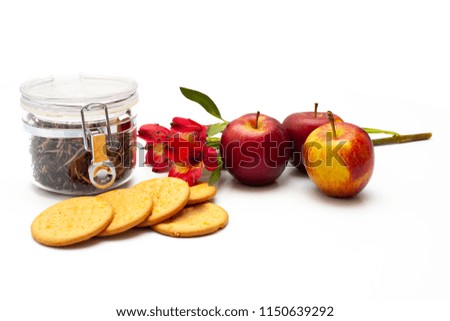 Jar with tea, flowers, apples, digestive biscuits