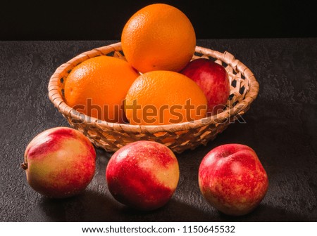 Ripe peaches nectarine in basket on wooden light background.