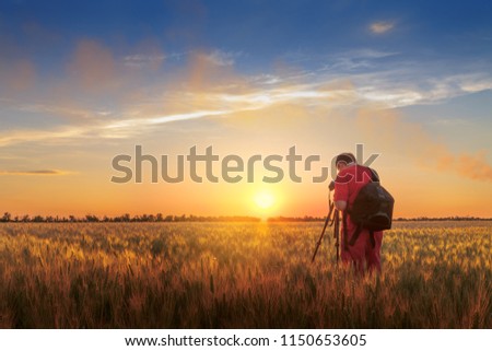photographer while working search for a story / evening landscape man on the field