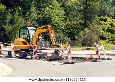 yellow excavator at road construction