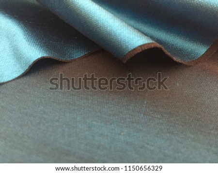 Woven texture of silk fabric or yarn turquois beige color changeable for background, horizontal foto. Crumbling edge. Draped folded satin. Advertising copy space.