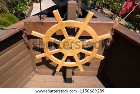 A wooden pirate ship helm steering wheel for kids.