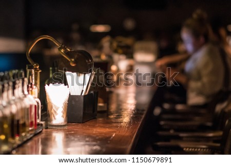 Bar design in classic vintage style. Oak wooden bar counter, comfortable chairs with leather upholstery and cooper rivets. Luxury interior. Great place for relax after work.  Royalty-Free Stock Photo #1150679891