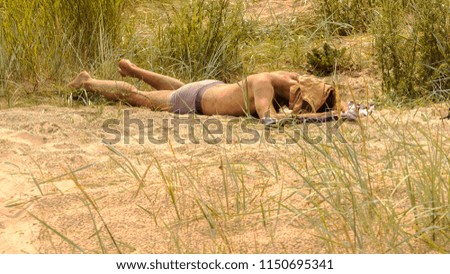 Vintage photo of of tanning man lying on beach in the city. Baltic sea shore. hot summer concept
