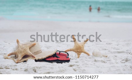 Summer vacation and holiday concept, starfish, beach hat and sea shell on sandy beach, green sea .