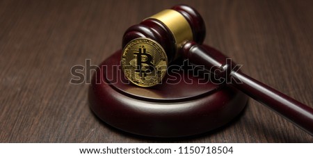  golden bitcoin on wooden pedestal of judge gavel