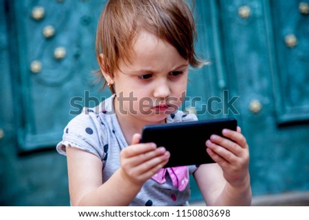 Social Media addiction. Little child girl holding smart phone (psychological problems, media mania, education concept)