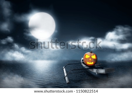 Halloween pumpkin in wooden boat on foggy lake at night