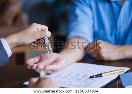 Real-estate agent giving keys to new property owners after signing contract,concept agreement and Real estate concept.real estate, moving home or renting property. Royalty-Free Stock Photo #1150837604