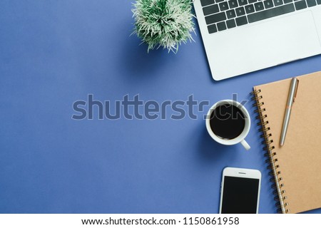 Office desk working space - Flat lay top view mockup photo of working space with laptop, smartphone, coffee up and notebook on blue pastel background. Pastel blue color background working desk concept Royalty-Free Stock Photo #1150861958