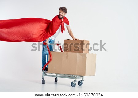 man with boxes and in a red raincoat, an iron wheelbarrow                              