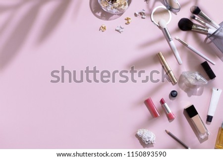 Flat lay and top view of make up products and cosmetics set on pink background with leaves shadow and Hard Light, copyspace. Beauty concept for blogger, pastel women business office table desk